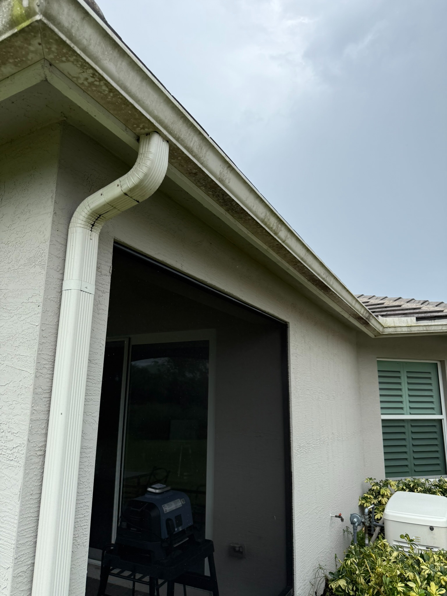 Gutter cleaning, side eave line in Tradition, FL — before